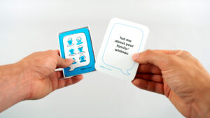 Hand holding Tell me about your family/whanau card from ACE Aotearoa conversation cards pack